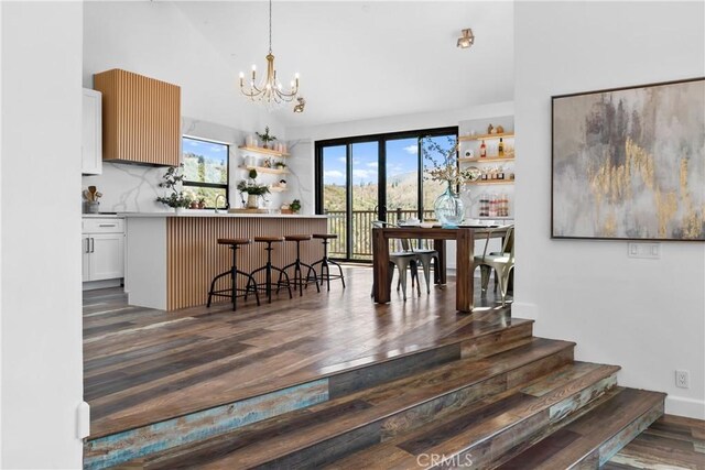 791 Cypress Rd, Lake Arrowhead, CA 92321 - dining area featuring a chandelier, healthy amount of natural light, dark wood-style floors, vaulted ceiling, and stairway