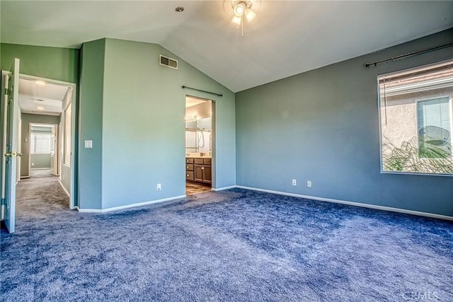 unfurnished bedroom with carpet floors, vaulted ceiling, baseboards, and connected bathroom