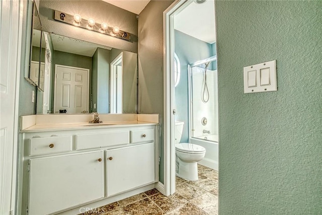 full bath with a textured wall, toilet, vanity, and shower / bathtub combination