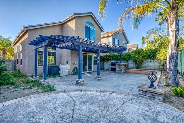 rear view of house with stucco siding, a pergola, a fenced backyard, a patio, and central air condition unit