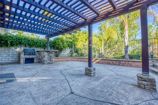 view of patio / terrace with a fenced backyard, an outdoor kitchen, and a pergola
