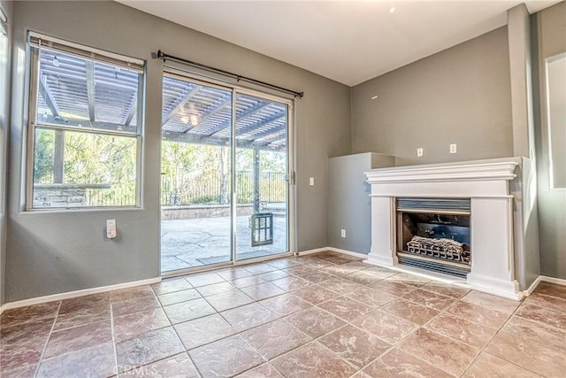unfurnished living room with baseboards and a fireplace