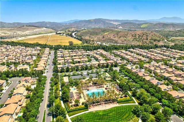aerial view of residential area featuring a mountainous background and a pool