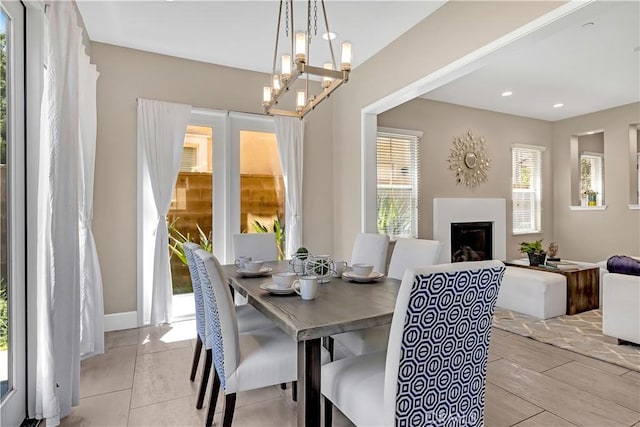 dining room featuring a fireplace and a chandelier