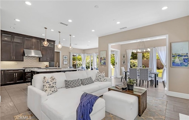 living area with recessed lighting, baseboards, and a chandelier
