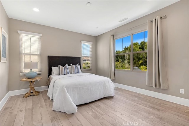 bedroom with light wood-type flooring, baseboards, and recessed lighting