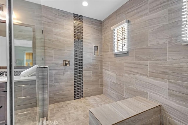 bathroom featuring tiled shower, vanity, and recessed lighting