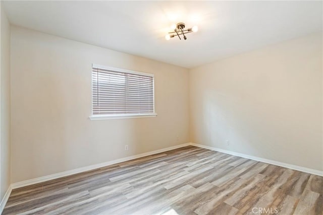 unfurnished room with light wood-style floors and baseboards
