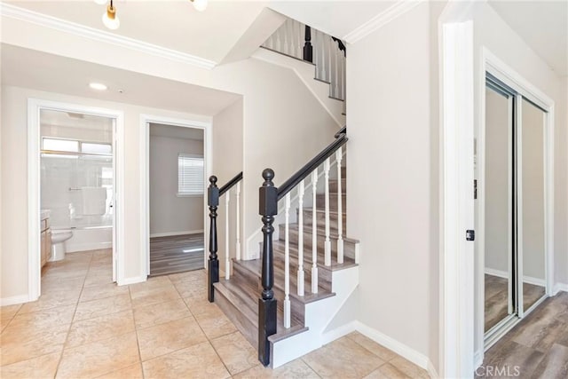 stairs with ornamental molding, baseboards, and tile patterned floors