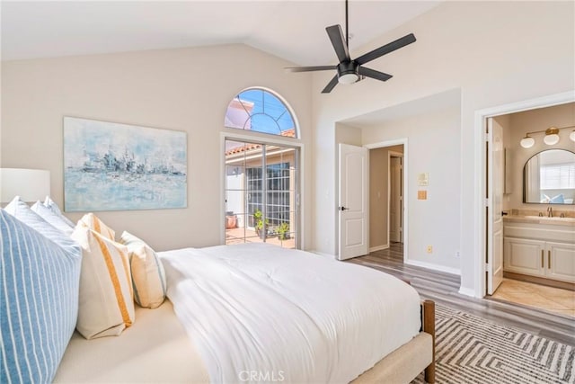 bedroom featuring lofted ceiling, ensuite bathroom, access to exterior, light wood finished floors, and a sink