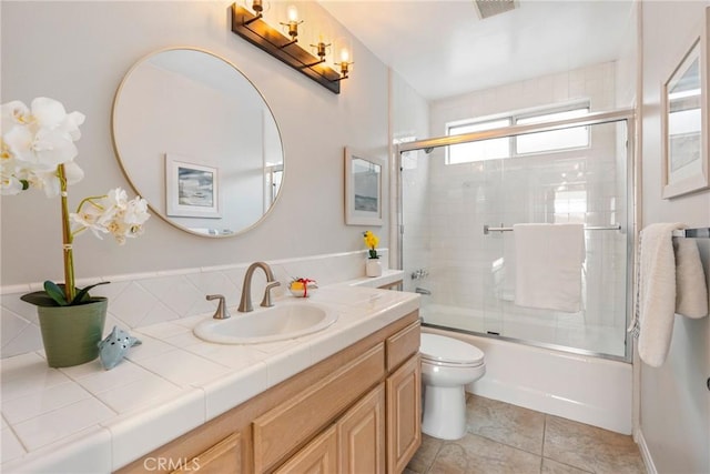 bathroom with vanity, enclosed tub / shower combo, toilet, and tile patterned floors