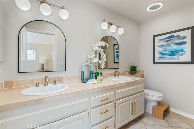 bathroom with toilet, double vanity, and tile patterned flooring