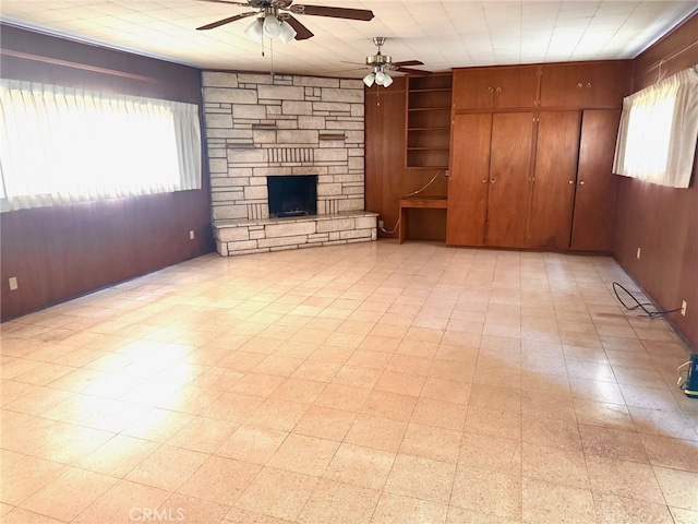 15602 Pitts Ave, Paramount, CA 90723 - unfurnished living room featuring a ceiling fan, a stone fireplace, and wooden walls