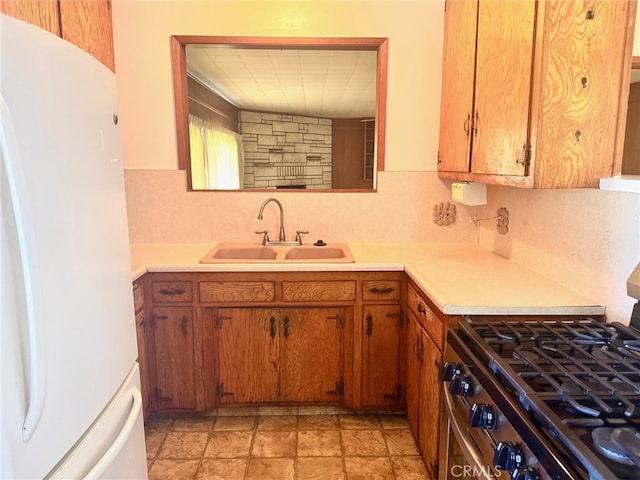 15602 Pitts Ave, Paramount, CA 90723 - kitchen featuring freestanding refrigerator, a sink, stainless steel gas stove, light countertops, and decorative backsplash