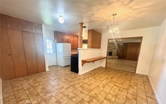 15602 Pitts Ave, Paramount, CA 90723 - kitchen with freestanding refrigerator, a peninsula, a chandelier, baseboards, and a breakfast bar area