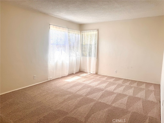 15602 Pitts Ave, Paramount, CA 90723 - spare room featuring light carpet, a textured ceiling, and baseboards