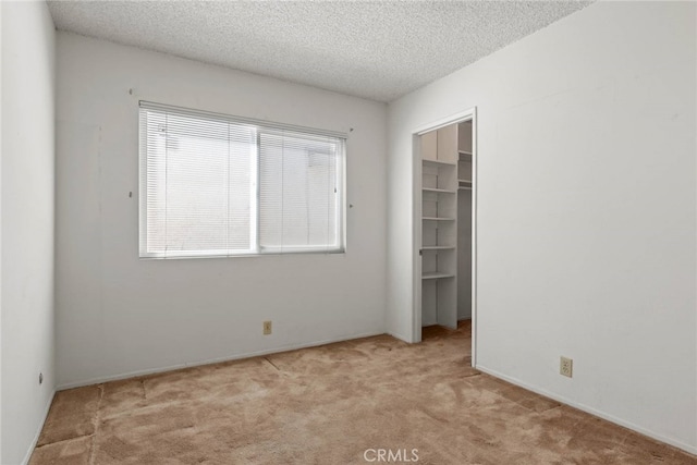 20081 Winfield Ct Unit 2, Yorba Linda, CA 92886 - unfurnished bedroom featuring carpet floors, a textured ceiling, a closet, a walk in closet, and baseboards