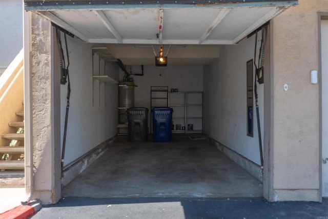 garage featuring strapped water heater and a garage door opener