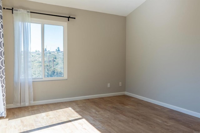 empty room featuring wood finished floors and baseboards