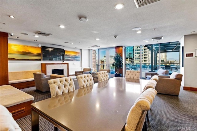 dining room with a fireplace, recessed lighting, a textured ceiling, carpet flooring, and healthy amount of natural light