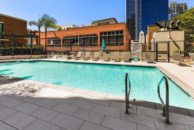 community pool with fence and a patio