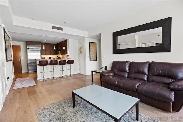 living room featuring light wood-type flooring and baseboards