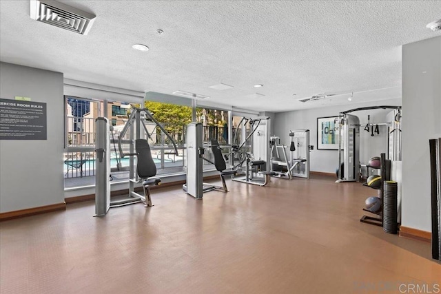 gym with baseboards and a textured ceiling