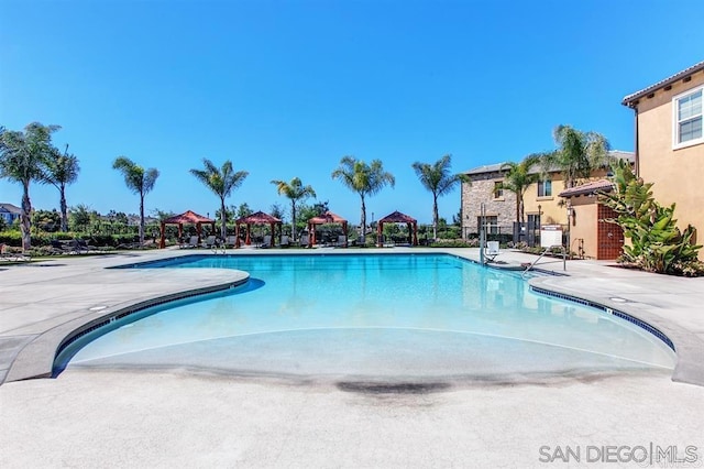 community pool with a gazebo and a patio area