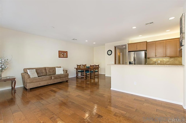 living room featuring dark wood finished floors, recessed lighting, and baseboards