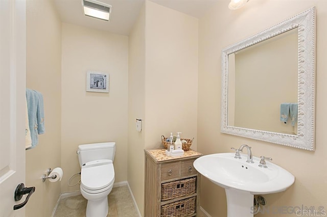bathroom with toilet, baseboards, a sink, and tile patterned floors