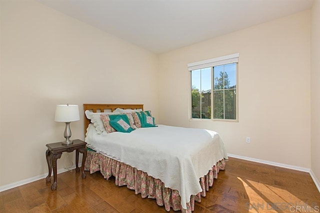 bedroom with baseboards and wood finished floors