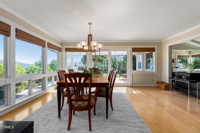 dining room featuring a chandelier, light wood-style floors, and crown molding