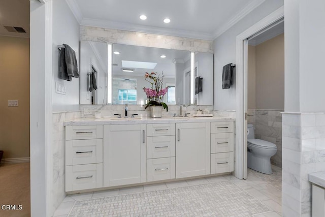 full bathroom featuring crown molding, a skylight, toilet, double vanity, and tile patterned floors