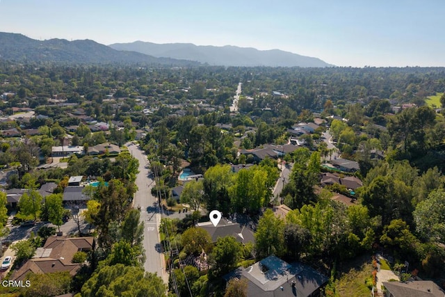 aerial view of property's location featuring a mountainous background and nearby suburban area