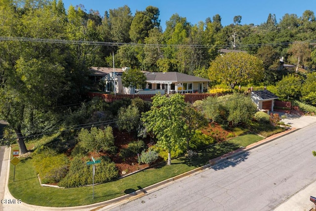 aerial view of property and surrounding area featuring a heavily wooded area