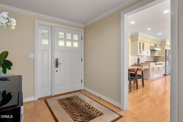 entryway with light wood-type flooring, ornamental molding, baseboards, and recessed lighting