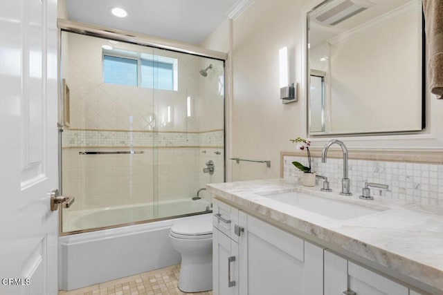 bathroom featuring toilet, enclosed tub / shower combo, vanity, crown molding, and recessed lighting