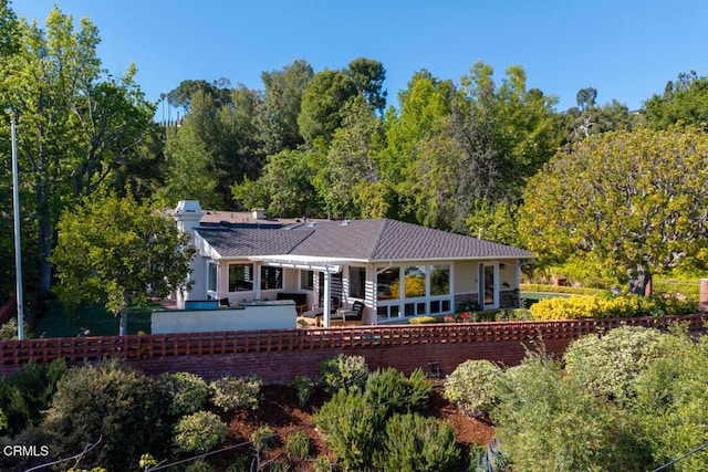 back of house with fence, a chimney, and a patio area