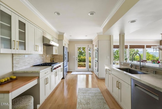 5109 Redwillow Ln, La Canada Flintridge, CA 91011 - kitchen featuring appliances with stainless steel finishes, wall chimney exhaust hood, light wood-style floors, decorative backsplash, and ornamental molding