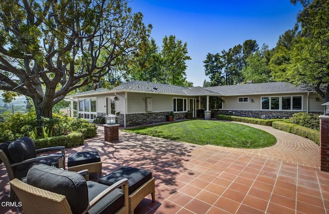 5109 Redwillow Ln, La Canada Flintridge, CA 91011 - back of house with stone siding, a lawn, and a patio