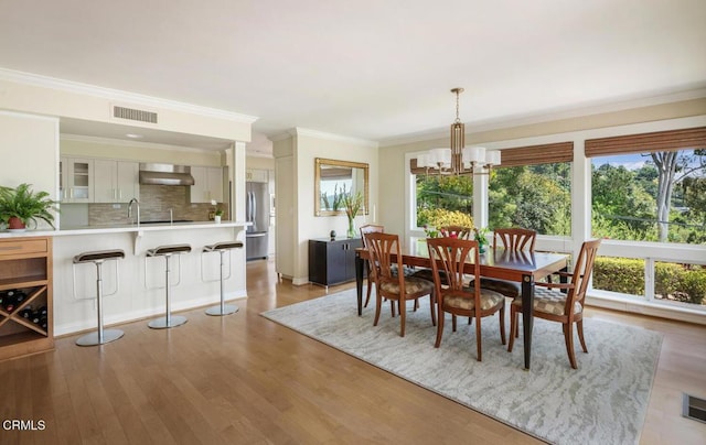 5109 Redwillow Ln, La Canada Flintridge, CA 91011 - dining area with plenty of natural light, a chandelier, light wood-style flooring, and crown molding