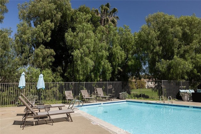 community pool with fence and a patio