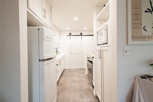 kitchen with white appliances, recessed lighting, white cabinetry, light countertops, and open shelves