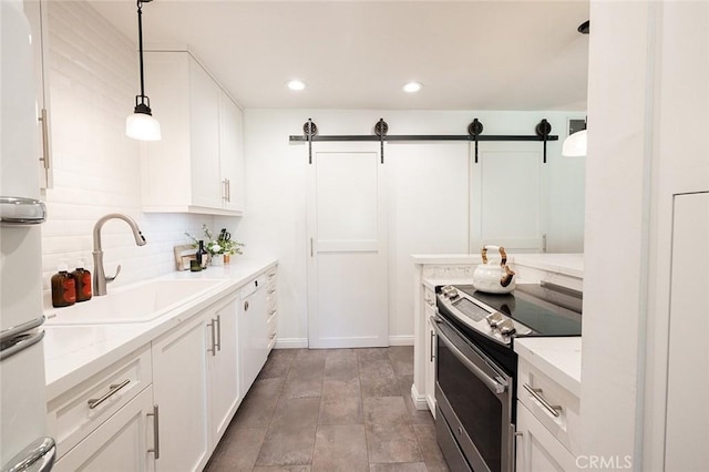 kitchen with stainless steel electric stove, a sink, white cabinetry, recessed lighting, and hanging light fixtures