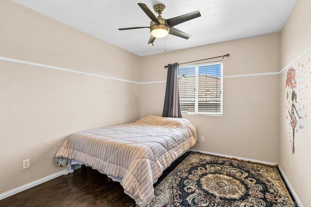 bedroom with baseboards, ceiling fan, and wood finished floors