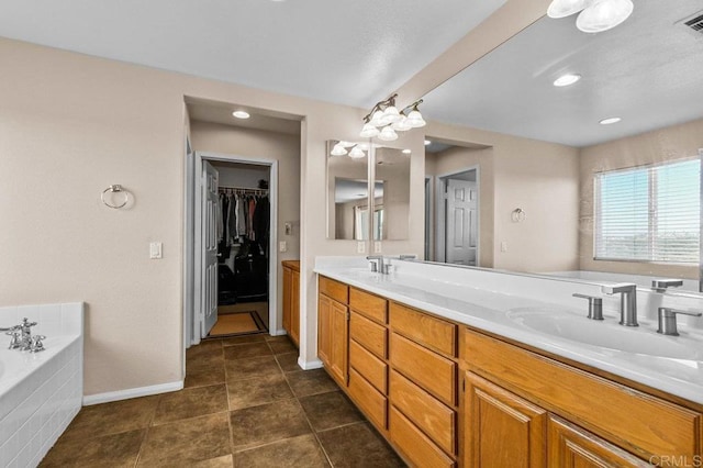 full bath with double vanity, a garden tub, baseboards, and a spacious closet