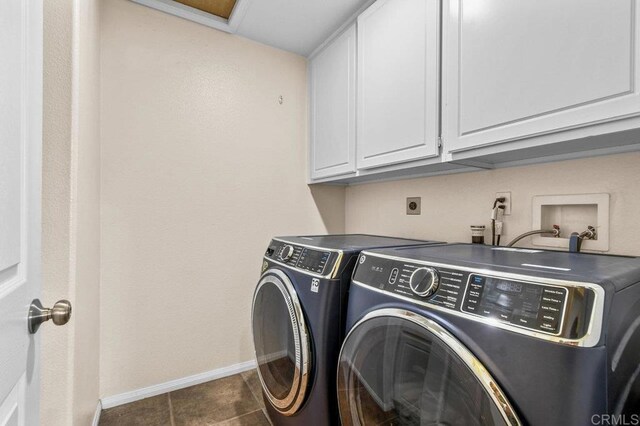 laundry room featuring cabinet space, baseboards, washer and dryer, and dark tile patterned flooring