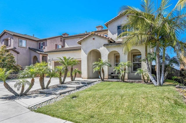mediterranean / spanish-style house featuring an attached garage, a chimney, a front yard, stucco siding, and driveway
