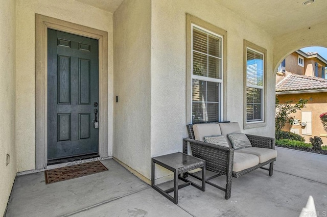 property entrance with stucco siding and covered porch