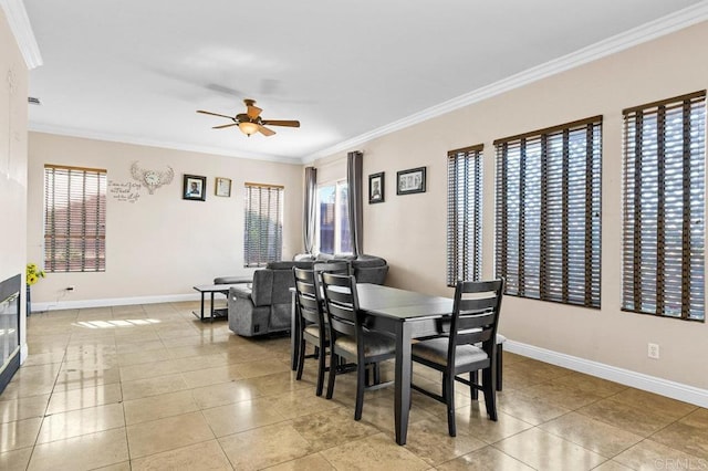 dining space with ornamental molding, plenty of natural light, a ceiling fan, and baseboards
